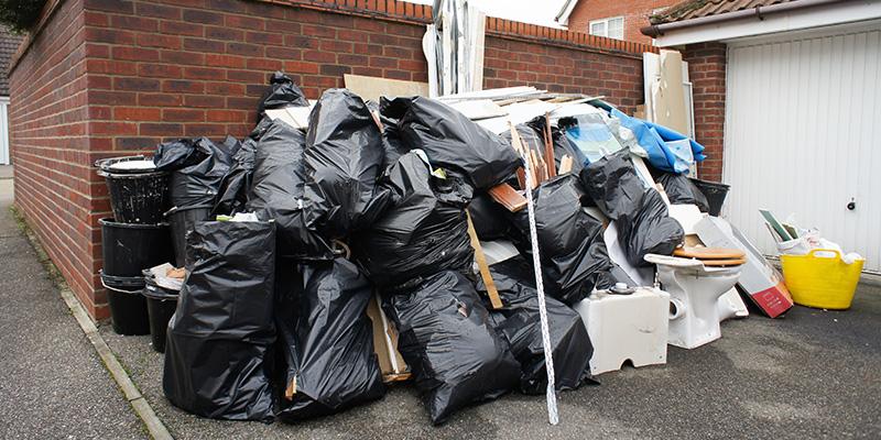 Property cleanout job in Kansas City displaying trash bags piled up outside of home.