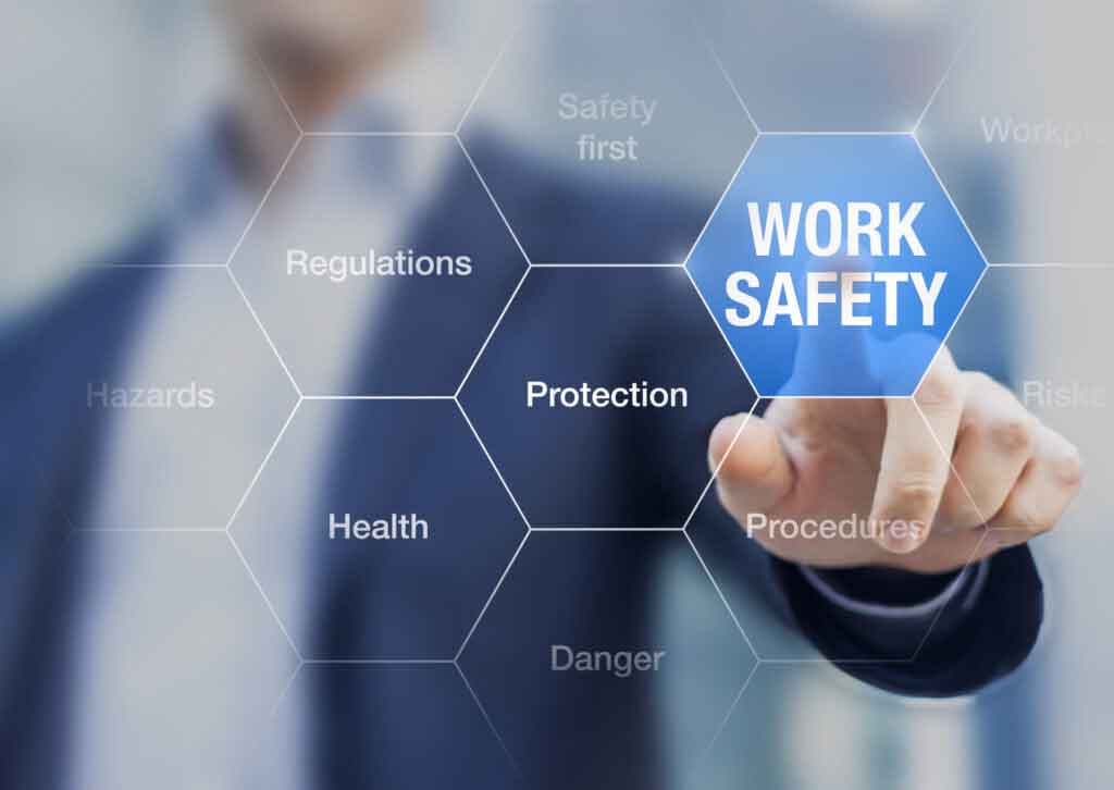 A man in a business suit pointing to a blue hexagon containing the word WORK SAFETY.